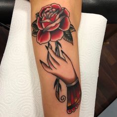 a woman's arm with a rose tattoo on it