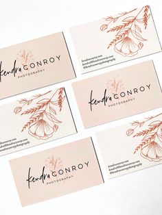 four business cards with flowers on them sitting next to each other in front of a white background