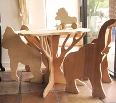 two wooden toys sitting on top of a tile floor next to a table and chair