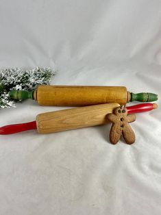 two wooden rolling pins, one with a ginger and the other with a green pepper