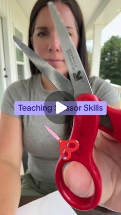 a woman is holding scissors in front of her face with the words teaching assist skills