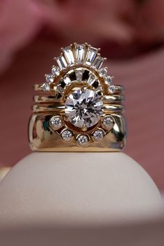 a close up of a ring on top of a white object with flowers in the background