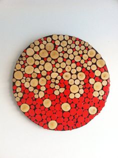 a red and brown circular object with circles on it's surface, made out of wood