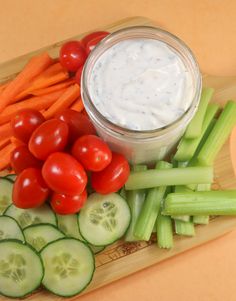 cucumber, carrots, celery and tomatoes on a cutting board