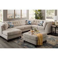 a living room scene with focus on the sectional sofa and footstool, along with a coffee table