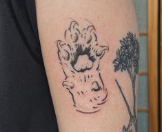 a person with a tattoo on their arm has a dog's paw in the shape of a head