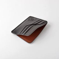 This wallet is made using top grain cowhide, featuring contrasted smooth and textured leathers for each card slot. The wallet features 4 card slots on either side and a interior pouch for bills. Made in CanadaGenuine Cowhide Leather Modern Leather Card Holder With Coin Pocket, Leather Business Card Holder With Interior Slots, Leather Wallets With Card Slots For Business, Black Leather Trifold Card Holder, Business Leather Trifold Wallet With Card Slots, Leather Bifold Card Holder For Business, Smooth Grain Bifold Card Holder For Business, Leather Trifold Card Holder With Leather Lining, Rectangular Leather Card Holder With Smooth Grain