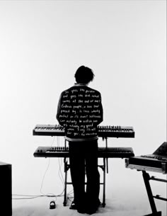 a man standing in front of a keyboard with writing on his jacket over his shirt