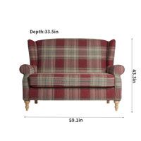 a red plaid couch sitting on top of a white floor