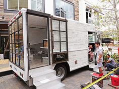 the people are getting ready to load their food truck into the back of the house