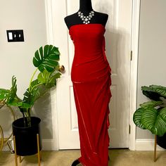 a mannequin with a red dress on display in front of a white door