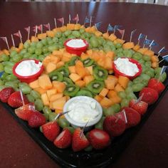 a platter filled with fruit and dips