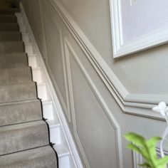 a white vase with flowers on top of the stairs