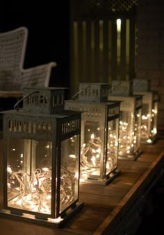 several lanterns lit up on a wooden table