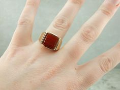 "Substantial and striking, this could be a great piece for a man or a woman! The style is classic Mid Century Modern, and has clean lines that keep the ring simple! The center is a smooth and warm Carnelian, which has a lovely orange-red hue! Metal: 10K Yellow Gold Gem: Carnelian .67 Grams Gem Measurements: 10.1 x 12.1 mm, Rectangle Ring Size: 10.25 Marks: \"10K N\" Stamped on the inside band SKU: K0DAEA-N Each piece has been identified and graded by a Graduate Gemologist who has been certified Classic Mid Century Modern, Rectangle Ring, Carnelian Jewelry, Carnelian Ring, Yellow Gold Wedding Ring, Jewelry Men, Wedding Elegant, Ring Simple, Men Ring