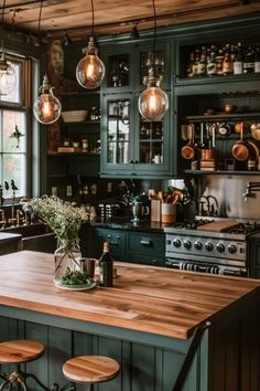 a kitchen with green cabinets and wooden counter tops, hanging lights over the stove top