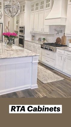 a large kitchen with white cabinets and marble counter tops, an island in the middle