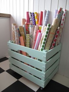 a crate filled with lots of different colored wrapping paper