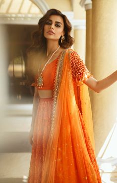 Traditional Orange Sharara With Sheer Dupatta, Elegant Orange Lehenga For Navratri, Bollywood Style Orange Choli For Transitional Season, Traditional Anarkali Set For Reception With Traditional Drape, Traditional Anarkali Set For Reception, Orange Lehenga With Zari Work For Transitional Season, Transitional Orange Lehenga With Zari Work, Orange Cutdana Sharara For Wedding, Traditional Sharara For Reception And Transitional Season