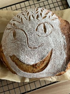 a cake with a smiley face drawn on it sitting on top of a cooling rack