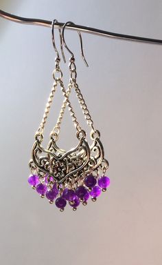 These beautiful chandelier earrings are made with natural Amethyst crystals round beads, silver plated connector, silver plated chain and ear wires. I love how the beads look different under different light, from a deep dark purple to a brilliant purple, almost magenta looking. They are lightweight and measure just a little bit over 1.5 inches making the perfect for almost any occasion. Dress up a summer dress or pair with a gorgeous gown for an elegant  look. Amethyst's calming influence on the Nickel-free Purple Dangle Chandelier Earrings, Handmade Purple Sterling Silver Chandelier Earrings, Bohemian Amethyst Chandelier Earrings Gift, Metal Chandelier Earrings With Dangling Beads, Nickel-free Purple Chandelier Earrings Gift, Purple Dangle Chandelier Earrings, Round Metal Chandelier Earrings With Dangling Beads, Elegant Nickel-free Chandelier Earrings With Round Beads, Elegant Czech Glass Chandelier Dangle Earrings