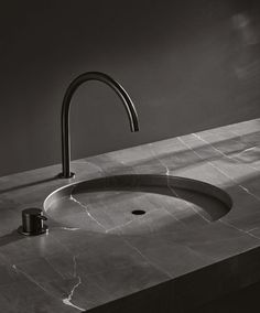 a black and white photo of a sink with a faucet in the middle