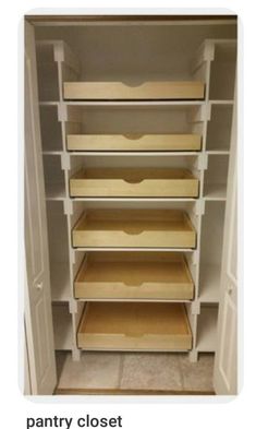 an empty closet with white shelves and wooden bins on the bottom shelf, along with tile flooring