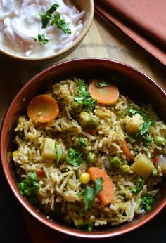 a bowl filled with rice, carrots and peas