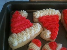 red and white frosted heart shaped cookies in a baking pan on top of a table