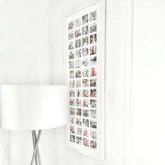 a white lamp sitting on top of a wooden table next to a wall mounted photo