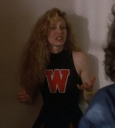 a woman with long hair standing in front of a mirror wearing a t - shirt that says w