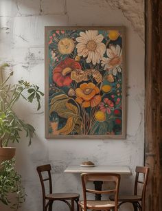 a painting hanging on the wall next to two chairs and a table in a room