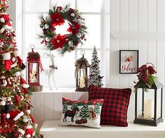 a decorated christmas tree in front of a window with wreaths and other holiday decorations