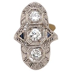 Art Deco three stone ring featuring three round diamonds weighing approixately 1 carat surrounded by a filigree mounting design. Two trilliant sapphires on each side. Tunnel Of Love, Three Stone Diamond, Three Stone Ring, Filigree Ring, Art Deco Diamond, Three Stone Rings, 1 Carat, Three Stone, Stone Ring