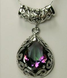 Mystic Topaz Pendant Necklace, Victorian Jewelry P28 This is a stunning Victorian inspired pendant necklace. This beautiful necklace is handcrafted from sterling silver. The flawless 6 carat man-made Mystic Topaz is a pear cut gemstone. Notice the beautiful craftsmanship of the silver filigree design. The teardrop shape setting outlines the lovely stone. The matching bail enhances the entire look. This necklace grabs attention with its simple beauty. Silver Drop Necklace With Jewels, Silver Briolette Gemstone Drop Necklace, Silver Drop Necklace With Gemstone Accents, Pear Shape Pendant, Pear Shaped Pendant, Topaz Pendant, Sterling Pendant, Filigree Design, Mystic Topaz