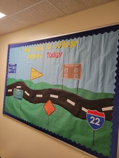 a bulletin board on the wall in an office with road signs and street signs painted on it