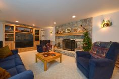 a living room with two blue couches and a fire place in the middle of it