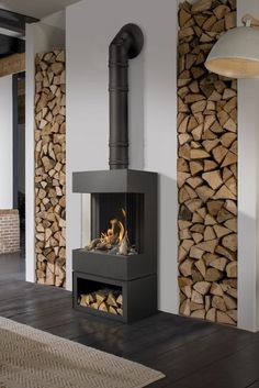 a fire place with logs stacked on the wall and wood burning in it's fireplace