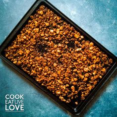 a square black tray filled with food on top of a blue countertop next to the words cook eat live love