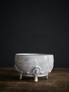 a white bowl sitting on top of a wooden table