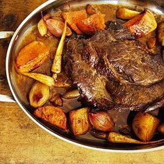 steak and potatoes in a pan on a wooden table