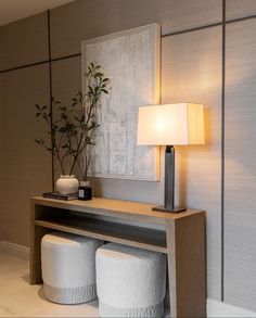 a modern living room with two stools and a table lamp in front of it