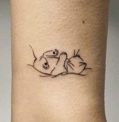 a small tattoo on the ankle of a woman's foot with an image of two cats