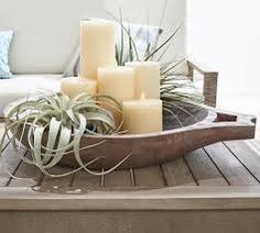 a tray with candles and air plants sitting on top of a wooden table next to a couch