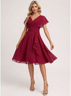 a woman wearing a red dress with short sleeves and a wrap around the waist,