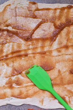 a green spatula sitting on top of some food