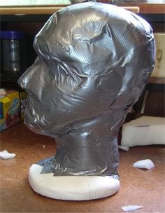 a plastic head is wrapped in silver foil