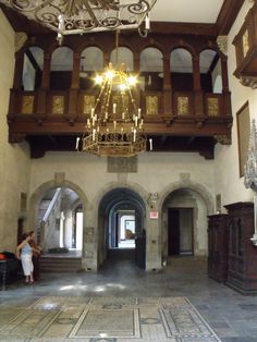 a chandelier hangs from the ceiling in an old building with stone flooring