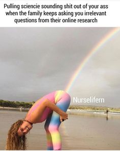 a woman is doing yoga on the beach with a rainbow in the sky behind her