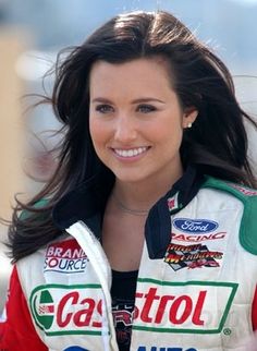 a woman with long hair wearing a racing jacket